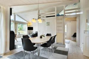 a dining room with a table and black chairs at LK1143-Lokken-Raevevej-5 in Løkken