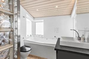 a white bathroom with a tub and a toilet at LK1861-Lokken-Ulstrupvej-25 in Løkken +19 photos