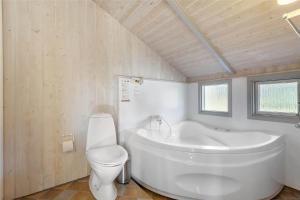 a bathroom with a white tub and a toilet at LK599-Lokken-Stellavej-16 in Løkken +14 photos