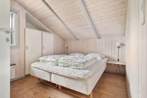 a large bed in a room with a wooden ceiling at LK599-Lokken-Stellavej-16 in Løkken