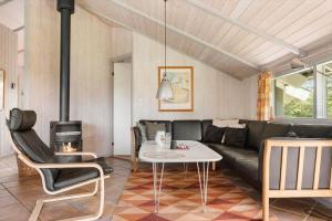 a living room with a black couch and a table at LK599-Lokken-Stellavej-16 in Løkken
