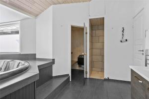 a bathroom with white walls and a sink and a mirror at LK1807-Lokken-Marthasvej-3 in Løkken +14 photos