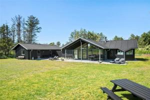 a black house with a picnic bench in the yard at LK1807-Lokken-Marthasvej-3 in Løkken