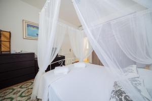 a bedroom with two beds with white mosquito nets at Gemma Del Sud - Centro Storico in Conversano