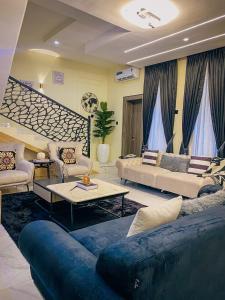 a large living room with couches and a staircase at FraMMa Homes in Akure