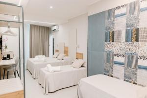 ペスカーラにあるStella D'Oro Roomsのベッド3台と机があるホテルの部屋