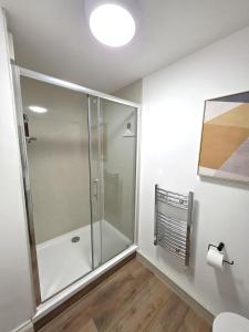 a glass shower in a bathroom with a toilet at Modern One Bed Flat at Dawe Luxury Suites - An Entire Apartment near Ely Cathedral & Train Station - The Perfect Gateway to Explore Ely, Cambridge, Norfolk & London - Sleeps up to 4 in Ely
