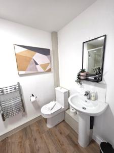a bathroom with a white toilet and a sink at Modern One Bed Flat at Dawe Luxury Suites - An Entire Apartment near Ely Cathedral & Train Station - The Perfect Gateway to Explore Ely, Cambridge, Norfolk & London - Sleeps up to 4 in Ely