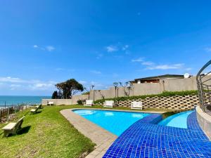 a swimming pool with a view of the ocean at Whale Rock, Margate by MRL in Margate