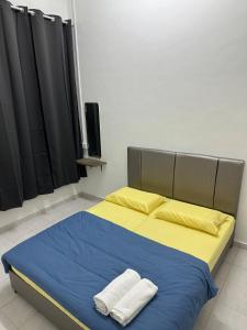 a bedroom with a bed with two towels on it at Aii Minsu in Kluang