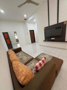 a living room with a couch and a flat screen tv at Aii Minsu in Kluang