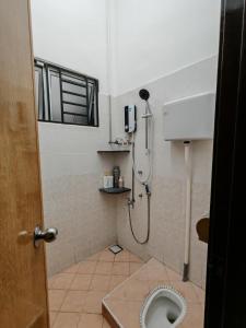 a bathroom with a shower and a toilet at Aii Minsu in Kluang