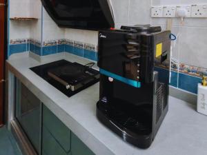 a kitchen with a stove with a coffee maker at Aii Minsu in Kluang