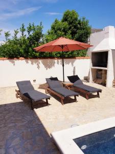 two lounge chairs and an umbrella next to a pool at Apartment 5237-2 in Batalaži