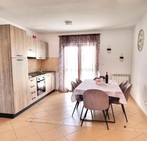 a kitchen with a table and chairs and a kitchen with a window at Apartment 5237-2 in Batalaži