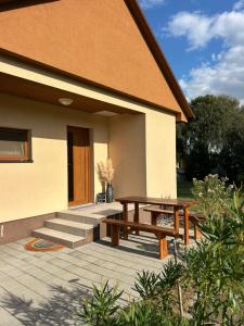 a patio with a picnic table and a bench at Domček Lodenica in Šintava +8 photos
