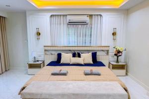 a bedroom with a large bed with blue sheets at Punsuk Poolvilla in Suan Lang +22 photos
