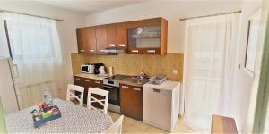 een keuken met houten kasten en een tafel en een tafel en een tafel bij Apartment 5237-1 in Batalaži