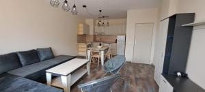Una sala de estar con un sofá y una mesa y una cocina. en Lighthouse GbA 304, en Balchik