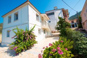 a white house with flowers in front of it at Marianna's and Aristidis' houses in Sívros