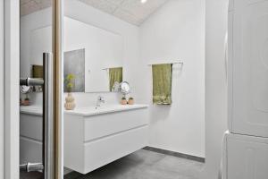 a white bathroom with a sink and a mirror at 244-Harboore-Knaresbrovej-17 in Harboør +35 photos