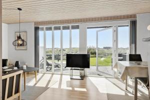 a living room with a tv and a large window at 115-Harboore-Strandvejen-164 in Harboør
