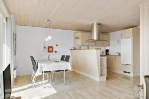 a kitchen and dining room with a white table and chairs at 115-Harboore-Strandvejen-164 in Harboør