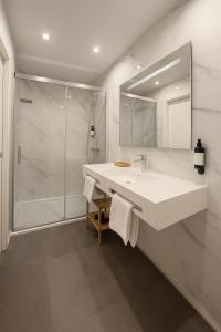 un bagno bianco con lavandino e doccia di Acetres 5 Boutique a Siviglia