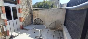 a patio with two chairs and a table and a fence at Joli duplex centre ville terrasse wifi clim in Châteauroux