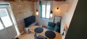 a living room with a table and a couch at Joli duplex centre ville terrasse wifi clim in Châteauroux