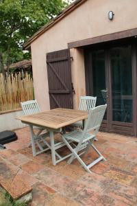 a wooden table and two chairs on a patio at La Petite Maison in Orgueil