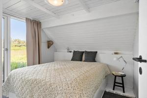 a white bedroom with a bed and a window at 296-Harboore-Knaresbrovej-23 in Harboør