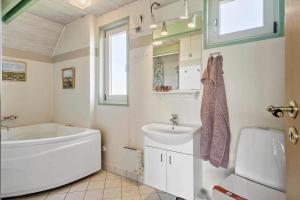un bagno con vasca, lavandino e WC di 300-Harboore-Fourmivej-29 a Harboør Altre 17 foto