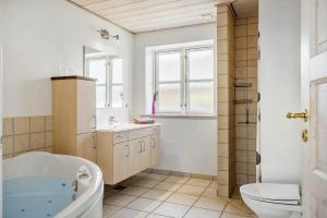 a bathroom with a tub and a toilet and a sink at 289-Harboore-Strandvejen-179 in Harboør