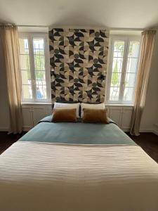 a large bed in a bedroom with two windows at Innocent VI face au palais in Avignon