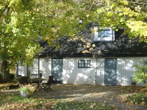 a white garage with a table and chairs in front of it at Trolleberg Bed & Breakfast in Veberöd