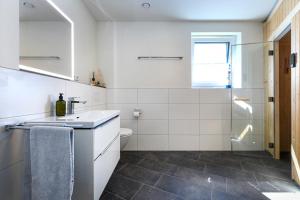 a white bathroom with a sink and a toilet at Wellenzauber in Kellenhusen +21 photos