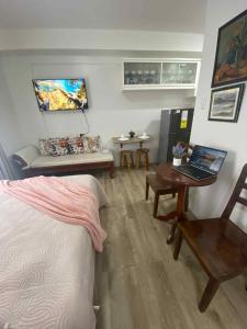 een slaapkamer met een bed en een bureau met een laptop bij Isabela 1 Mesavirre Residences in Bacolod