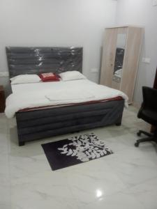 a bedroom with a bed and a mirror and a rug at CITY CHARM Home Stay in Dehradun