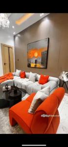 a living room with a couch and an orange chair at Luxury 2 bedroom in Lekki