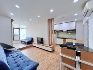 a living room with a blue couch and a tv at Gold Ocean Apartment Nha Trang in Nha Trang