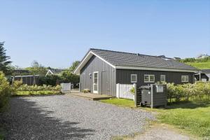 a gray house with a gravel driveway in front of it at G139-Lemvig-Porsevej-39 in Lemvig