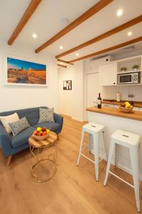 un soggiorno con un divano blu e una cucina di Acetres 5 Boutique a Siviglia