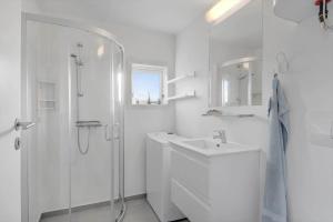 a white bathroom with a shower and a sink at 163-Harboore-Vejlby-Klit-47 in Harboør +24 photos