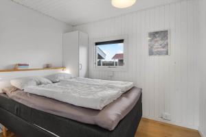 a large bed in a room with a window at 163-Harboore-Vejlby-Klit-47 in Harboør