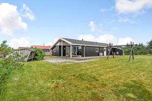 a black house with a large yard at 163-Harboore-Vejlby-Klit-47 in Harboør