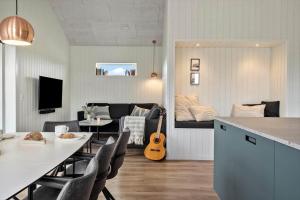a living room with a table and a living room with a guitar at 341-Harboore-Gloryvej-27 in Harboør