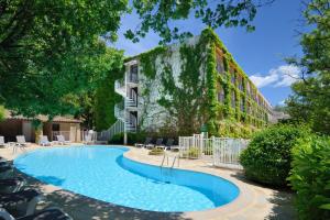 格雷乌莱班Villa Borghese, The Originals Relais的建筑物前的游泳池