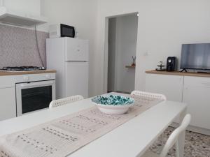 a white kitchen with a table with a bowl on it at Appartamento 42 in Noicattaro