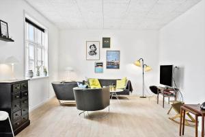 a living room with chairs and a couch and a tv at 713-Thyboron-Vesterhavsgade-34 in Thyborøn